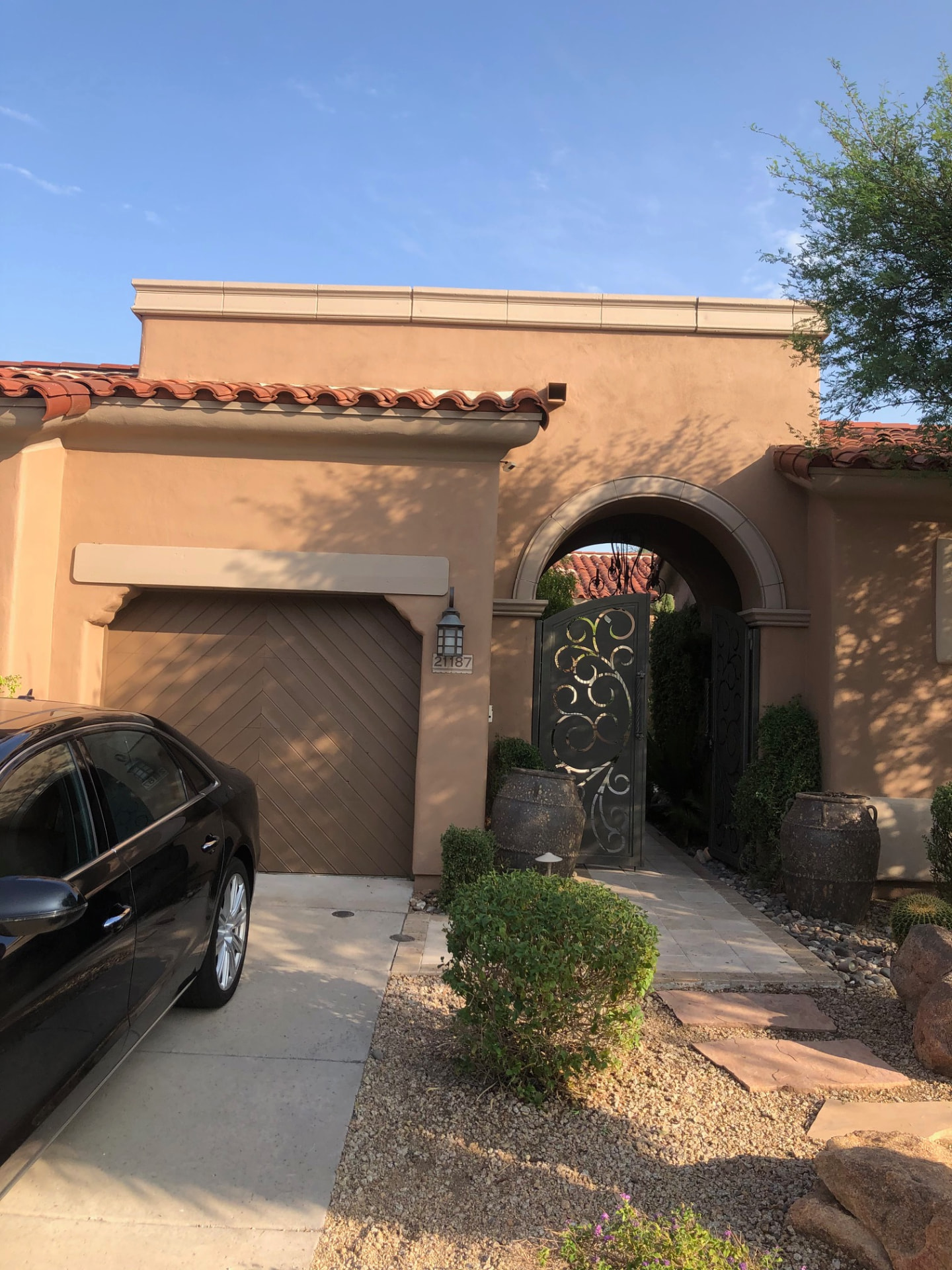 Freshly painted home entry with a wood garage door, painted trim beam and stucco surround